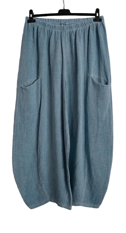 Light blue linen wide-leg pants with side pockets, hanging on a black hanger against a white background