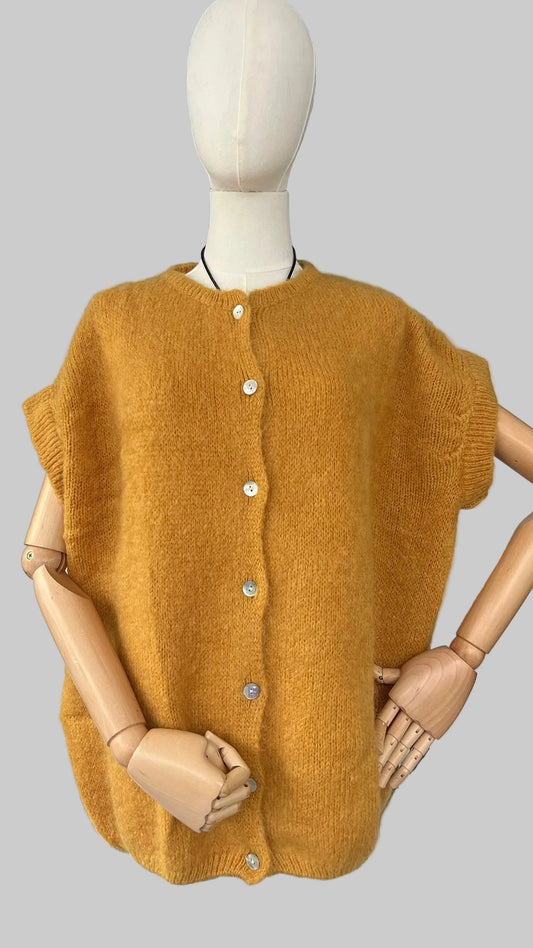 Mustard yellow knitted vest on a mannequin against a white background